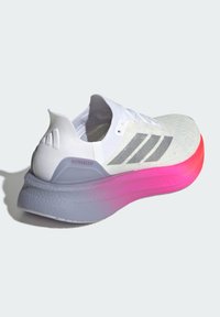 Bílé sportovní boty s přechody od růžové k fialové podešvi, třemi stříbrnými pruhy na boku, texturovaným síťovým svrškem a měkkým polstrováním.