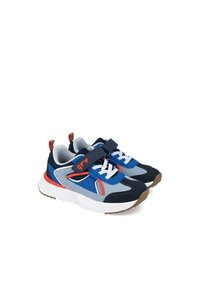 Zapatillas azul y marino con acentos rojos, materiales de malla y ante, una correa de Velcro, cordones blancos y una suela blanca gruesa y acolchada.