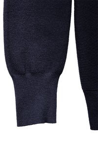 Stickad marinblå tröja med ribbade manschetter och en texturerad kropp, som visar en jämn finish med varierade mönster i tyget.