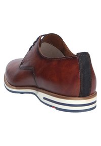 Bruine leren schoen met een ronde neus, textiele hielstrook en witte zool met blauwe en rode strepen. Glad oppervlak met subtiele stiksels.