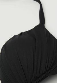 Černý bikiny top s texturovaným, skladaným designem. Nastavitelný popruh a bezšvové okraje. Vyrobeno z měkké, elastické tkaniny pro pohodlí.