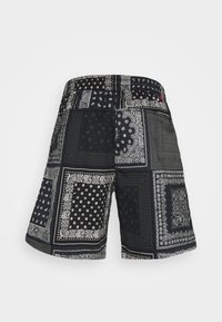 Černé šortky s potiskem bandany a bílými vzory, elastický pas a hladká textura. Stylový design s různými čtvercovými motivy.