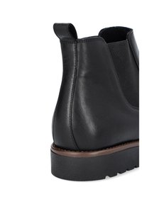 Czarne skórzane botki za kostkę z elastycznymi panelami bocznymi, zaokrąglonym noskiem oraz niską, teksturowaną gumową podeszwą; posiadają pętelkę u pięty.