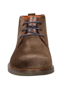 Bruine suède enkellaarsjes met marineblauwe veters en een accent van tan leer. Rondere neus en een getextureerd oppervlak, voorzien van een rubberen zool en stikseldetails.