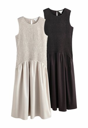 To ærmeløse midikjoler, en beige og en sort, med teksturerede tætsiddende livstykker og glatte, indsamlede skørter.