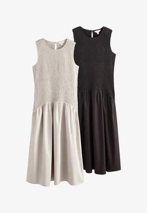 Kaks varrukateta midi pikkusega kleiti, üks beež ja teine must, tekstuursete kehakestega ja sujuvate, voltidega seelikutega.