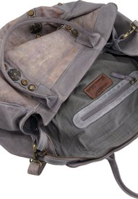 Graue Lederhandtasche mit einem strukturierten, metallischen Innenfutter. Ausgestattet mit bronzefarbenem Zubehör und einer Reißverschlusstasche, die mit einem braunen Markenschild versehen ist.