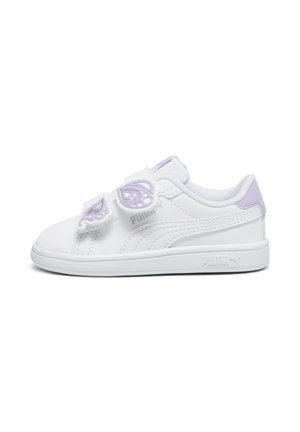 Baskets basses blanches Puma avec des accents lilas et deux brides en velcro en forme de papillon sur un fond blanc uni.