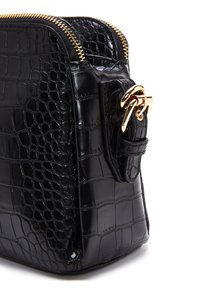 Sac en cuir noir avec une texture crocodile, équipé de quincaillerie dorée et d'une fermeture éclair. Forme rectangulaire compacte avec un détail de bandoulière sur le côté.