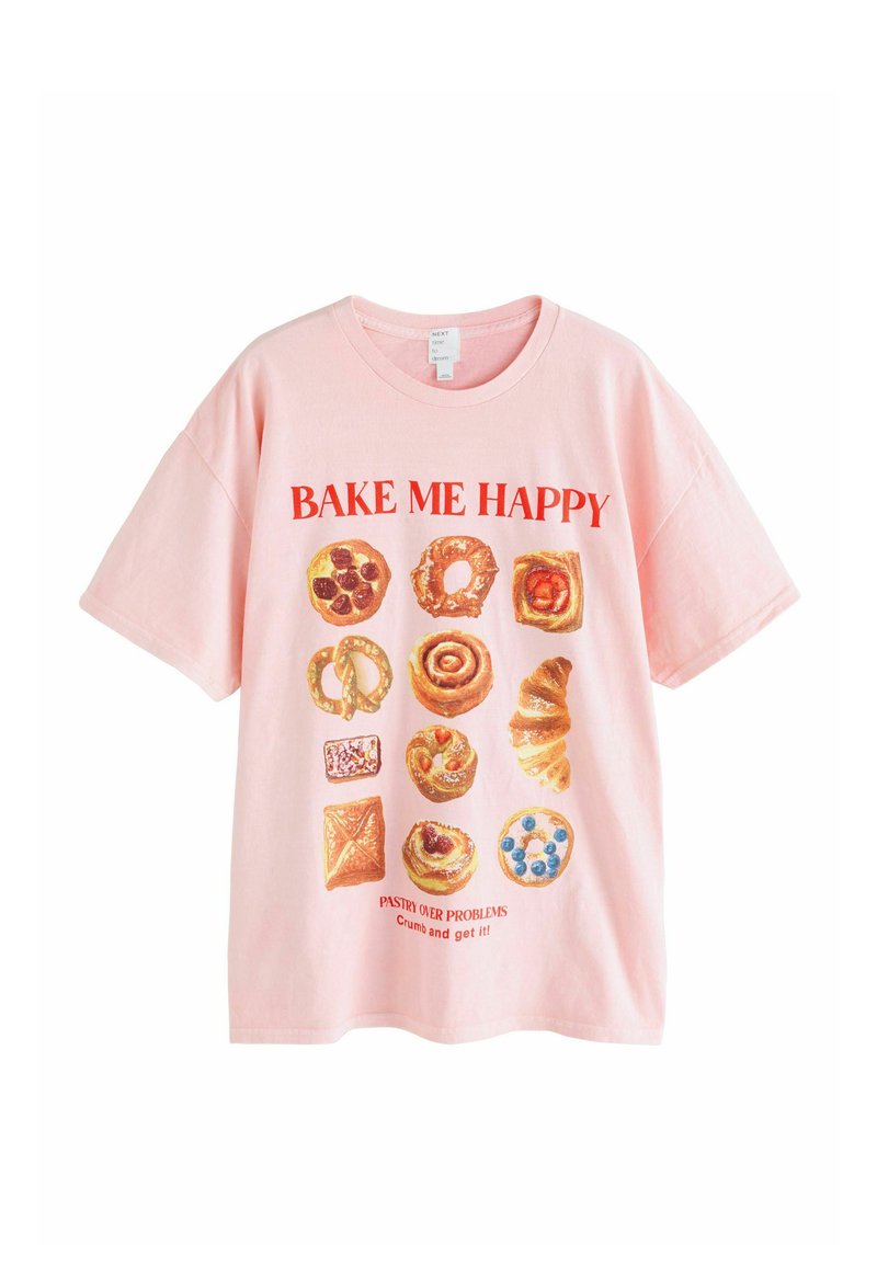 Różowa bawełniana koszulka z krótkim rękawem, z grafiką ciast i tekstem „BAKE ME HAPPY” oraz „PASTRY OVER PROBLEMS” w kolorze czerwonym. Luźny krój.