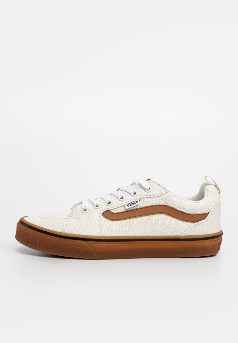 Zapatillas de lona blancas con acentos marrones, parte superior texturizada, cordones planos, suela de goma y una franja oscura alrededor de la base.