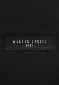 Schwarzes Stoffetikett mit dem Text "WERNER CHRIST" und "BABY" in Weiß, mit einer strukturierten Oberfläche und rechteckiger Form.