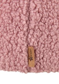 Close-up of soft, pink, curly textured fabric with a small tan leather tag labeled "Sterntale" sewn into the seam.