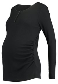 Blusa de maternidade preta feita de tecido canelado, com mangas longas, um decote redondo e botões na parte da frente. Detalhes franzidos nas laterais.