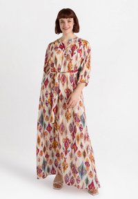 Maxi-mekko, joka on koristeltu värikkäällä ikat-kuviolla vaaleanpunaisen, oranssin ja teal-sinisen sävyissä, jonka kauluksellinen päänäkö ja vyötärölle kiristettävä vyö, valmistettu kevyestä kankaasta.