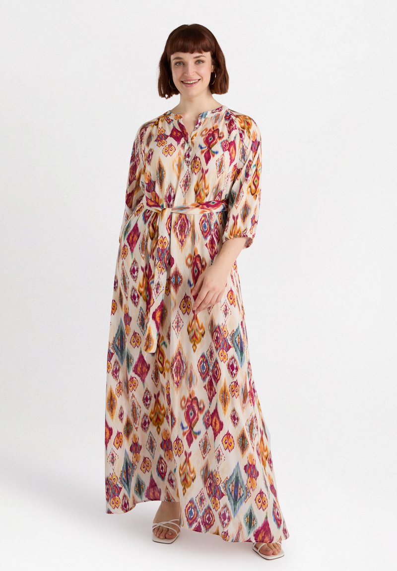 Maxi-mekko, joka on koristeltu värikkäällä ikat-kuviolla vaaleanpunaisen, oranssin ja teal-sinisen sävyissä, jonka kauluksellinen päänäkö ja vyötärölle kiristettävä vyö, valmistettu kevyestä kankaasta.