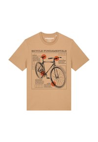 Bruine t-shirt met een grafische illustratie van een fiets met gelabelde onderdelen. Tekstdetails bevatten 'Fiets Fundamenten' en diagramaccenten.