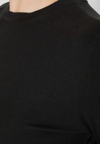 Svart bomullströja med klassisk rundad halsringning, korta ärmar och en slät, odekorerad yta.