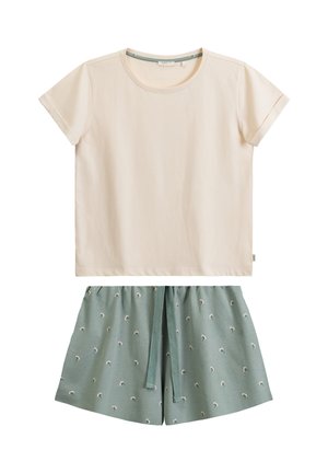 Beżowa bluzka z krótkim rękawem w połączeniu z zielonymi szortami z sznurkiem w pasie i małym białym kwiatowym wzorem, ułożone płasko na białym tle.