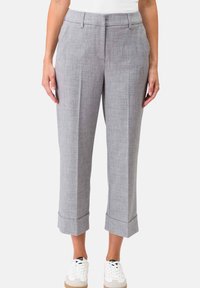Grijze textuurbroek met een slim fit, voorzien van een omgeslagen zoom en zijzakken, gedragen met witte casual sneakers.
