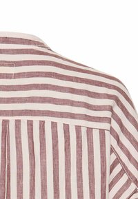 Linned skjorte med tynde horisontale striber i lys og mørk beige, med en rygfold og en rund pasform ved halsen.