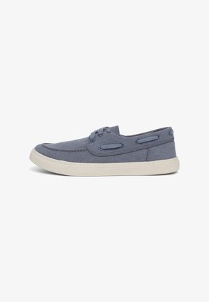 Scarpa da ginnastica blu in tela con suola in gomma crema, design a basso profilo, lacci e cuciture decorative. Presenta fori per i lacci e una superficie superiore текстurizzata.