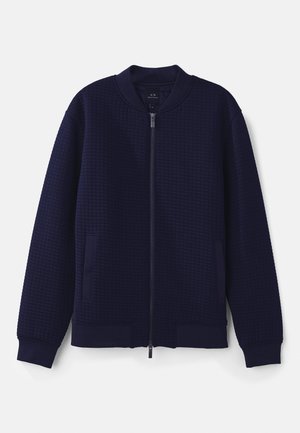 Navy blue bomber jacket made from textured fabric with a zip front, ribbed cuffs, and two side pockets. Features a round collar design.