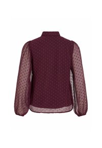 Blouse bordeaux à pois, avec un col, des manches longues en organza et un dos droit. Texture douce avec des couches de tissu.