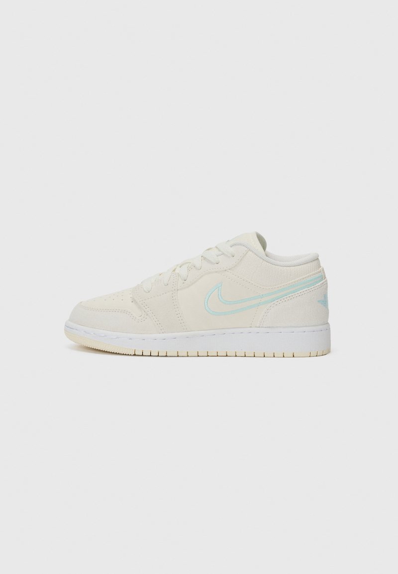 Nike sneakers in off-white suede with a light blue swoosh, low-top design, round toe, and textured surface. Features a white rubber sole.