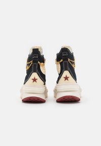 Sneakers alte con una toma navy, dettagli crema, stella rossa, decorazioni in catena dorata e suole in gomma testurizzata.