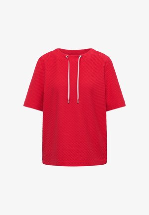 Top rosso a maniche corte con texture, scollo rotondo e cordini bianchi che pendono da occhielli vicino al colletto.