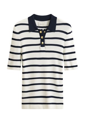 Polo blanc à manches courtes en tissu côtelé avec rayures horizontales bleu marine, col bleu marine et trois boutons dorés sur la patte de boutonnage.