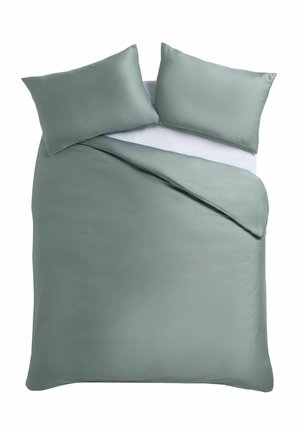 Doppelbett mit hellgrünem Bettbezug und zwei passenden Kissen auf weißem Spannbettlaken, eine Ecke der Bettdecke ist zurückgefaltet.