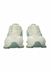 Sneakers met een combinatie van witte leer en lichtgrijs suede, met een gestructureerde zool en beige accenten. De veters zijn crème-kleurig.