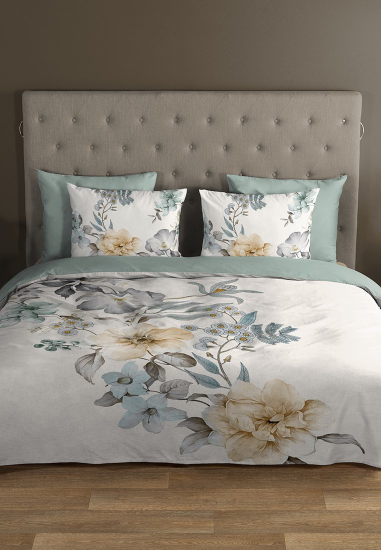 Blumiges Bettbezug-Set mit sanften Blau- und Beigetönen, das große Blumen und Blätter auf einem hellen Hintergrund zeigt. Enthält passende Dekorationskissen.