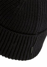 Sort strikket beanie-hat med ribbet tekstur, rund form og et lille logomærke på siden. Blødt uldblandingsmateriale.