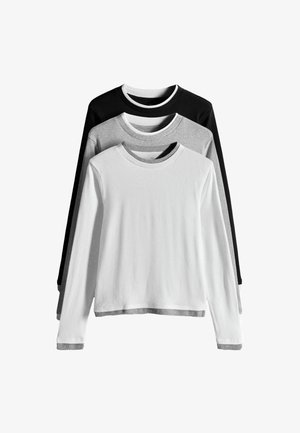 Tri tričká s dlhým rukávom a okrúhlym výstrihom vrstvené z predu dozadu v bielej, sivej a čiernej farbe s kontrastnými vnútornými goliermi a manžetami.
