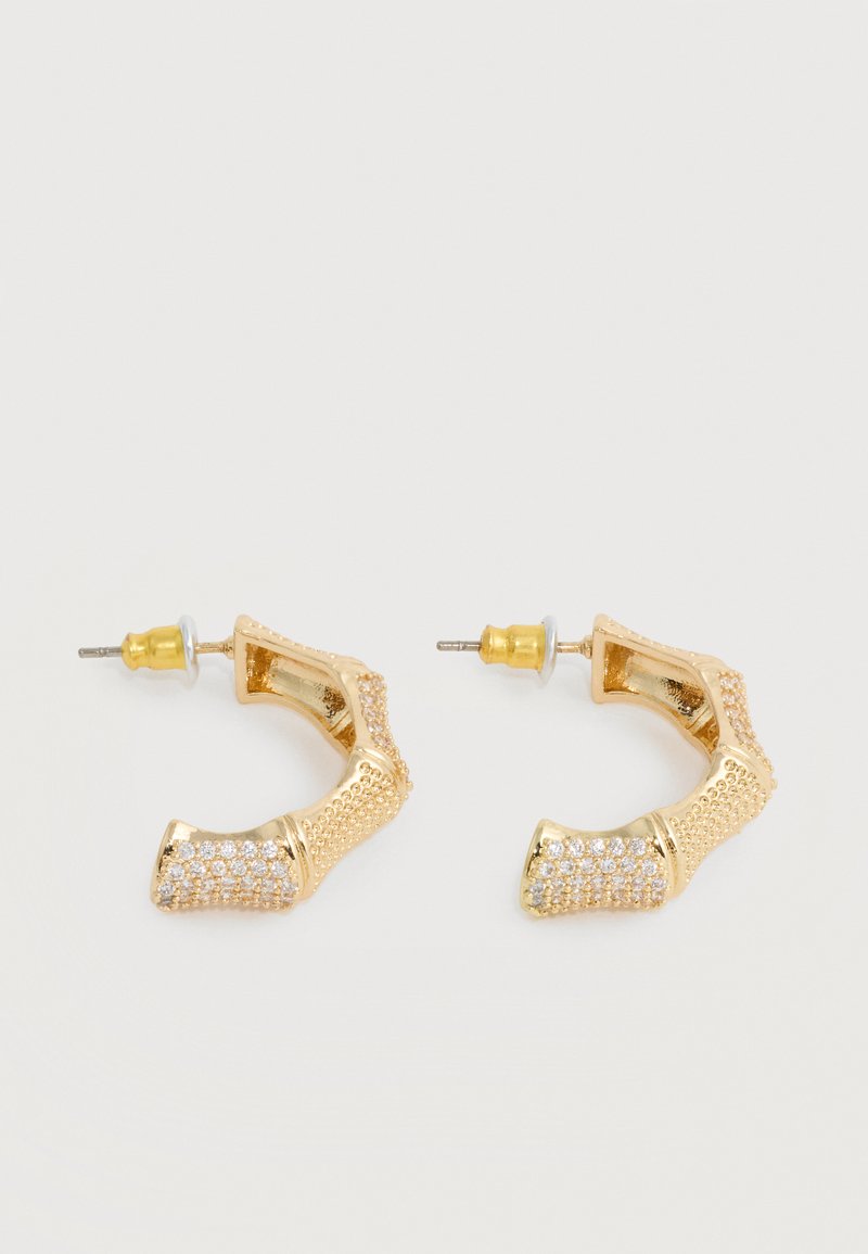 Oorringen in goudkleur met bamboevorm en kleine heldere kristallen aan de onderkant, met achterste sluitingen.