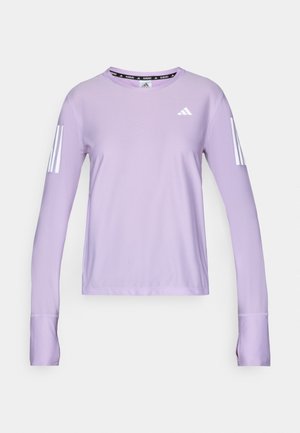 T-shirt de sport à manches longues lilas en tissu texturé. Présente trois rayures blanches sur chaque manche et un col rond avec un détail de logo noir.