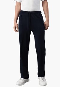 Marineblaue Jogginghose aus weichem Material, mit einem elastischen Bund und Kordelzug sowie einer lockeren Passform entlang der Beine.