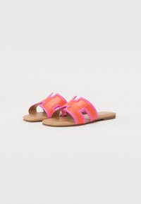 Orange slides with pink accents and open toe design, featuring a cut-out 'H' pattern, made of smooth synthetic material and flat soles.