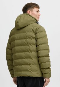 Puffjakke i olivengrønn, med hette, quiltet design og glatt tekstur, i en lett innsnittet fasong med elastiske mansjetter.