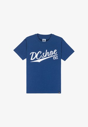 Niebieska bawełniana koszulka z krótkim rękawem, z dużym białym logo "DCshoe Co." w stylu kursywy z przodu.