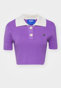 Polo shirt violet à manches courtes avec un col côtelé blanc, trois boutons et un petit logo sur la poitrine. Fabriqué en tissu en maille côtelée.