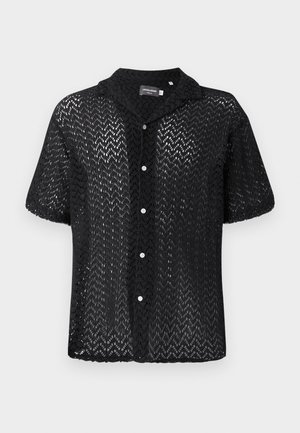 Must mustriga lühikeste varrukatega särk, mis on valmistatud pitsmaterjalist ja millel on chevron-muster, krae ja nööpidega esikülg, millel on valged nööbid.