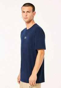 Navy blue short-sleeve t-shirt made of smooth fabric, featuring a small logo on the chest. Simple round neckline and relaxed fit.