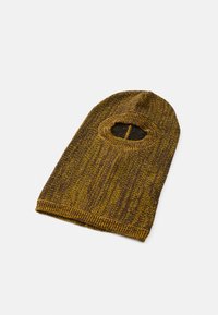 Strikket balaklava i brun og sennepsgult med et teksturert mønster. Har en åpning for øynene og en tettsittende passform rundt ansiktet og halsen.