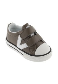 Bruine en witte peutersneaker met twee klittenbandsluitingen, een witte neuskap en een wit zigzagpatroon aan de zijkant.