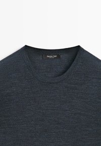 Dunkelgrauer Rundhalsausschnitt-Strickpullover mit feiner Textur, der den oberen Brust- und Kragenbereich mit einem sichtbaren "Massimo Dutti"-Etikett zeigt.