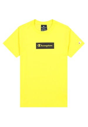 T-shirt jaune vif à manches courtes avec un patch logo rectangulaire noir affichant « Champion » en écriture jaune sur la poitrine.